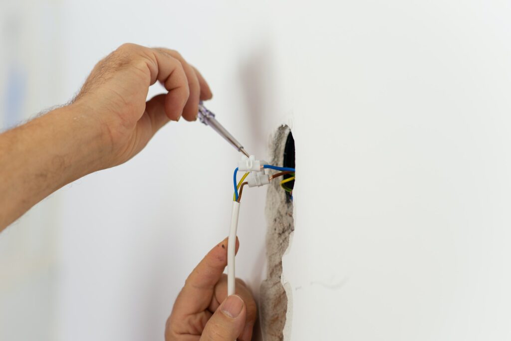 Electrician checking the presence of electrical current in a wire circuit in a home