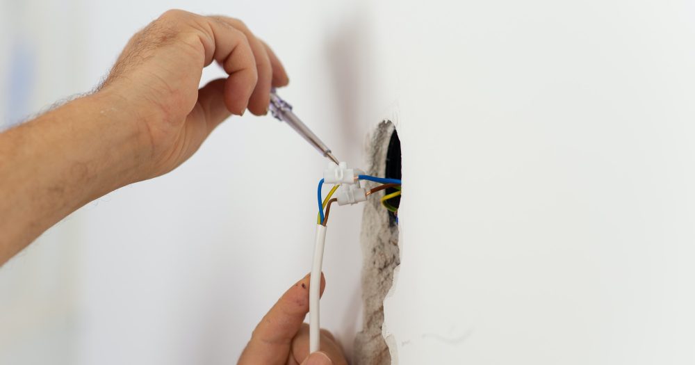 Electrician checking the presence of electrical current in a wire circuit in a home